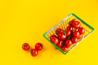A shopping basket, filled with plump tomatoes