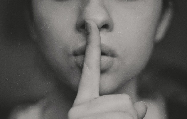 A pair of lips and a finger, making the 'shh' gesture
