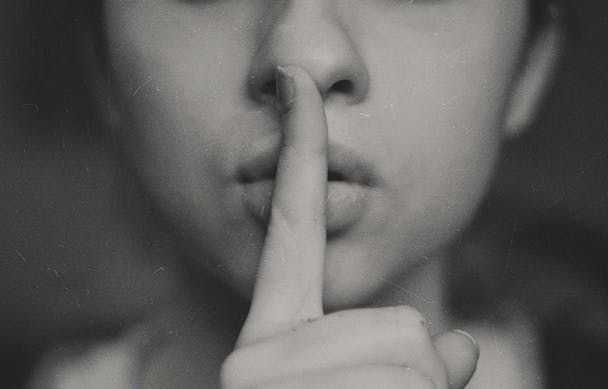 A pair of lips and a finger, making the 'shh' gesture A pair of lips and a finger, making the 'shh' gesture