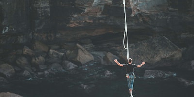 A man walking a tightrope over a canyon