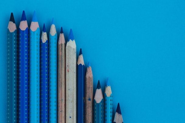 A number of blue pencils standing upright