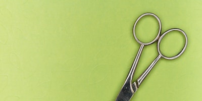 A pair of scissors on a green background