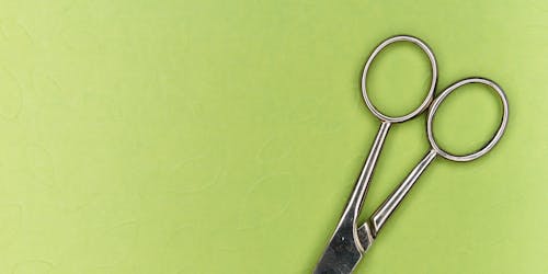A pair of scissors on a green background A pair of scissors on a green background