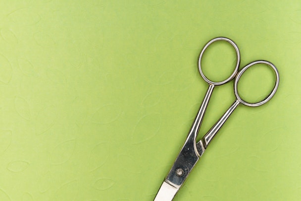 A pair of scissors on a green background
