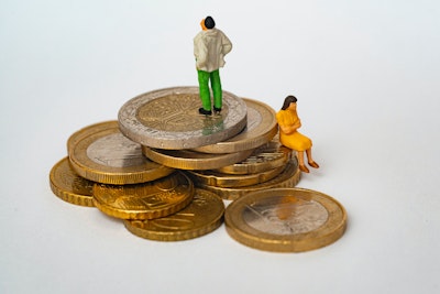 Tiny toy people sat on piles of Euro coins