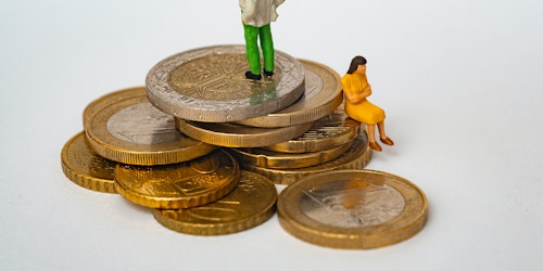 Tiny toy people sat on piles of Euro coins
