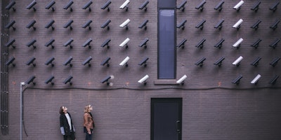 A wall of security cameras, pointed at two people