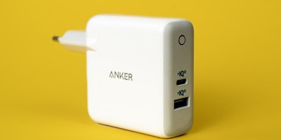 An Anker charging plug against a yellow background