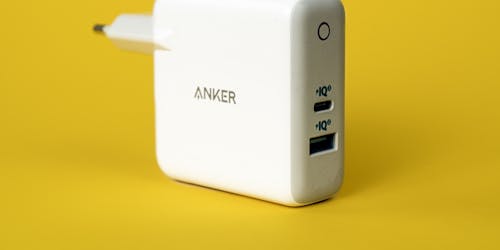 An Anker charging plug against a yellow background An Anker charging plug against a yellow background
