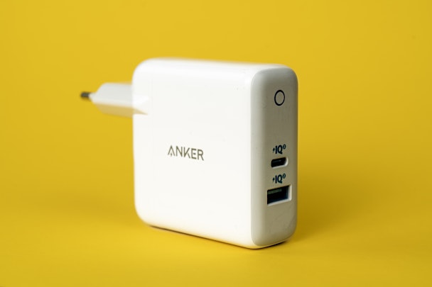 An Anker charging plug against a yellow background