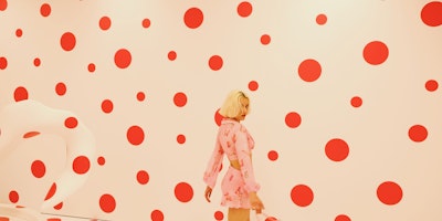 A woman at a Yayoi Kusama red-and-white polkadot exhibition