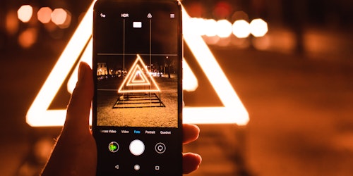 A phone on a tripod taking a picture of a triangular light display