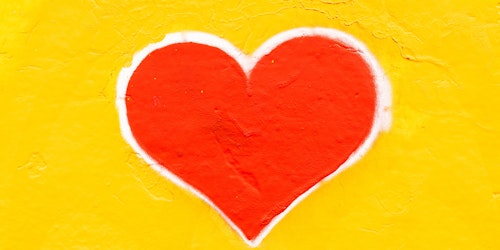Graffiti of a red heart on a yellow wall