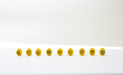 A row of Lego heads with angry expressions on their faces