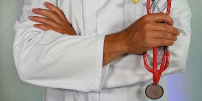 A doctor's arms, holding a stethoscope 