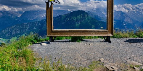 A large, empty picture frame in an idyllic mountain location