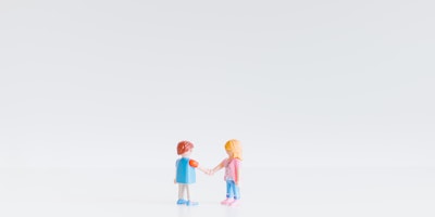 Two Lego figurines shaking hands