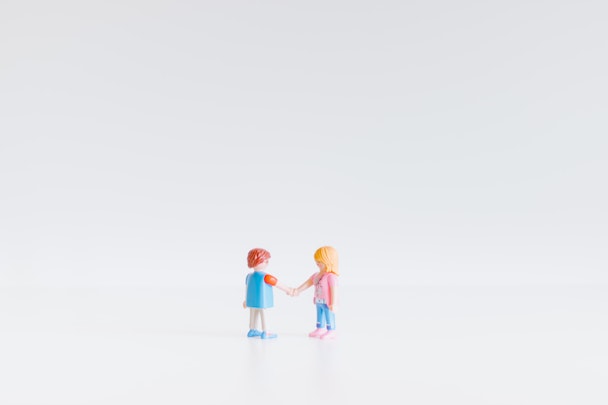 Two Lego figurines shaking hands
