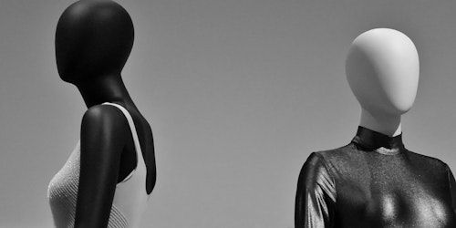 Two futuristic mannequins, one black wearing silver; the other silver wearing black.