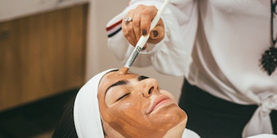 A relaxed looking person, receiving a facial treatment