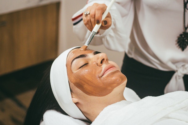A relaxed looking person, receiving a facial treatment
