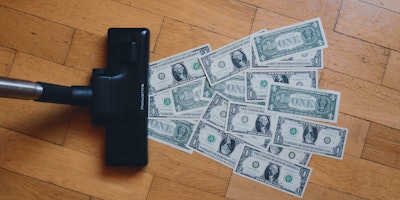 A vacuum cleaner, hoovering up dollar bills