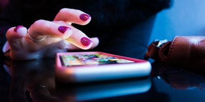 A person's hand, scrolling on the homescreen of a smart phone