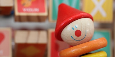A wooden children's toy that looks like a clown
