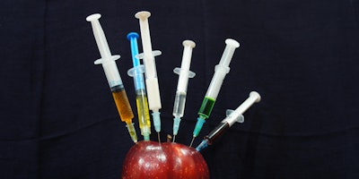 An apple, with syringes in it