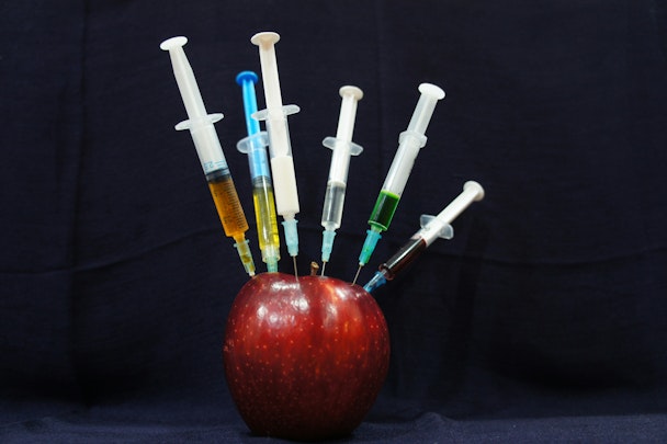 An apple, with syringes in it