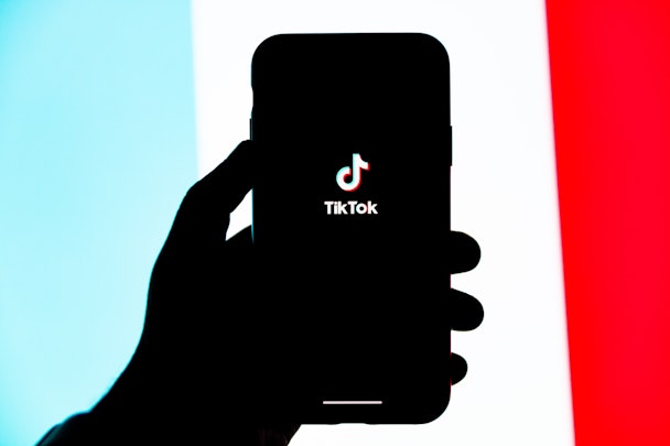 Een hand die een telefoon vasthoudt met de TikTok-app