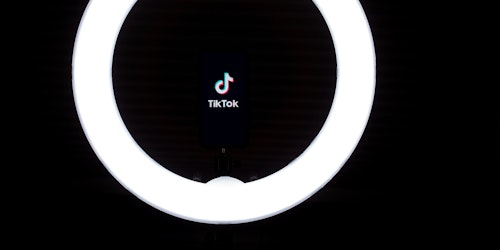 The TikTok logo, lit by a ring light