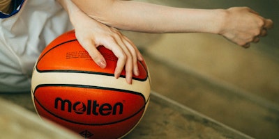 A woman's hand on a basketball
