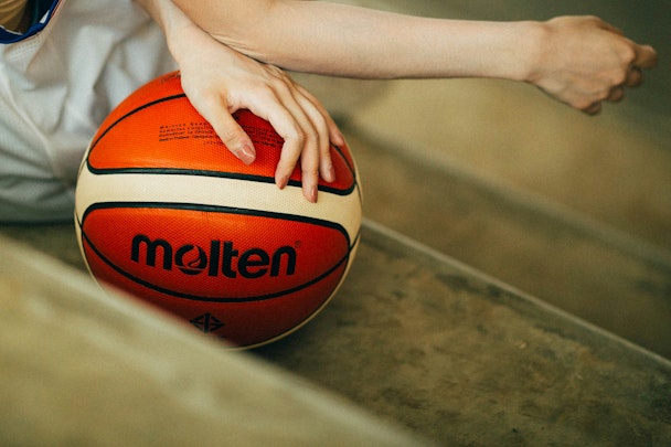 A woman's hand on a basketball