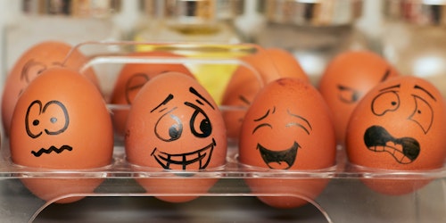 Eggs in a box, with faces drawn onto them depicting an array of emotions