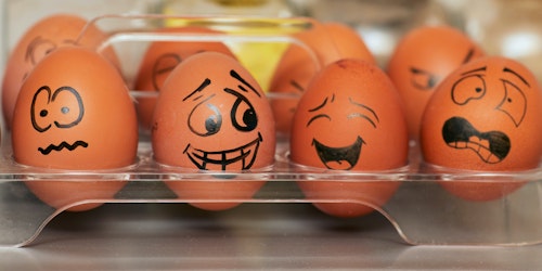 Eggs in a box, with faces drawn onto them depicting an array of emotions