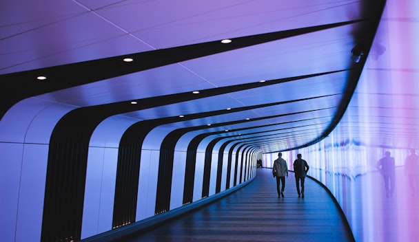 Two people walking down a futuristic-looking hallway