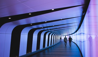 Two people walking in a futuristic-looking hallway