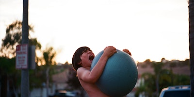 A boy squeezing an exercise ball