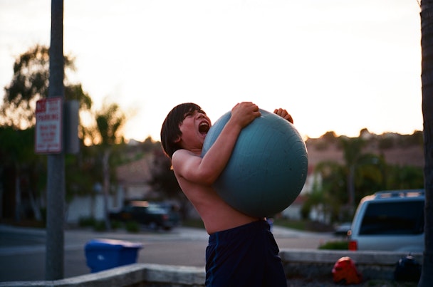 A boy squeezing an exercise ball