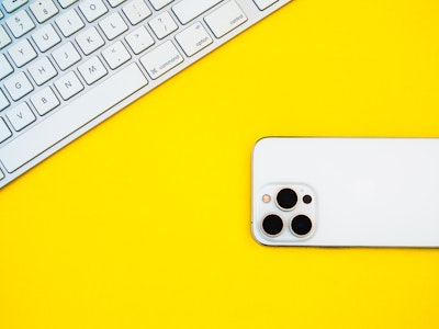 A phone and keyboard on a yellow background