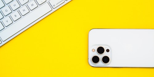 A phone and keyboard on a yellow background