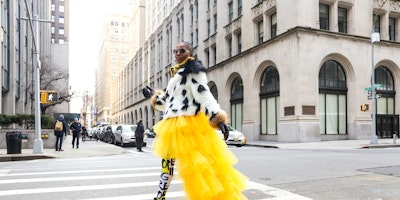 A stylish woman in yellow clothes crossing a New York street