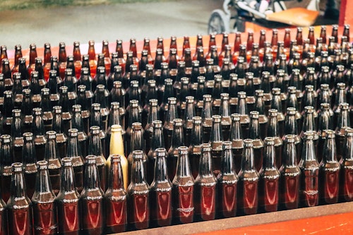 A production line of bottles, one of them gold in a sea of normality