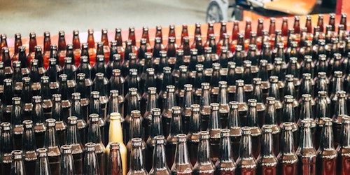 A production line of bottles, one of them gold in a sea of normality