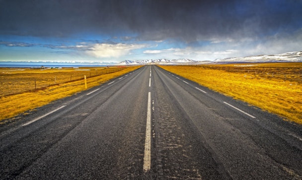 A prairie road leading to a mountain range