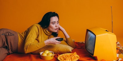 A woman watching an advert on a TV that has followed the biggest 2024 advertising trend of emotion