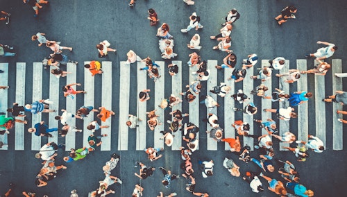 People, crossing a pedestrian cross, representing audience targeting with digital out of home