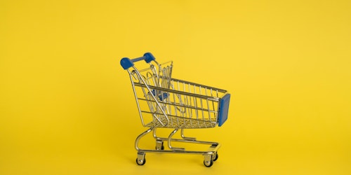 A retail shopping trolley amid a yellow background