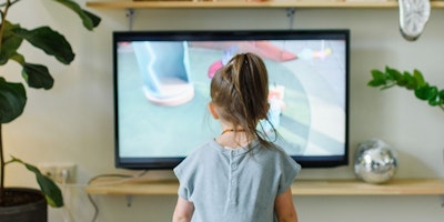 A small girl kid / child watches the television